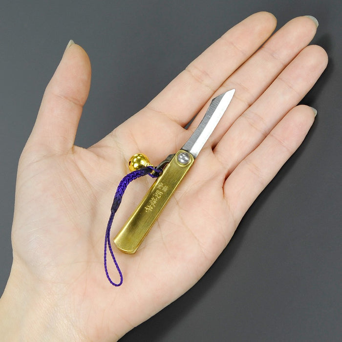 Higonokami SK Steel Bell Brass XS shown in hand for size reference