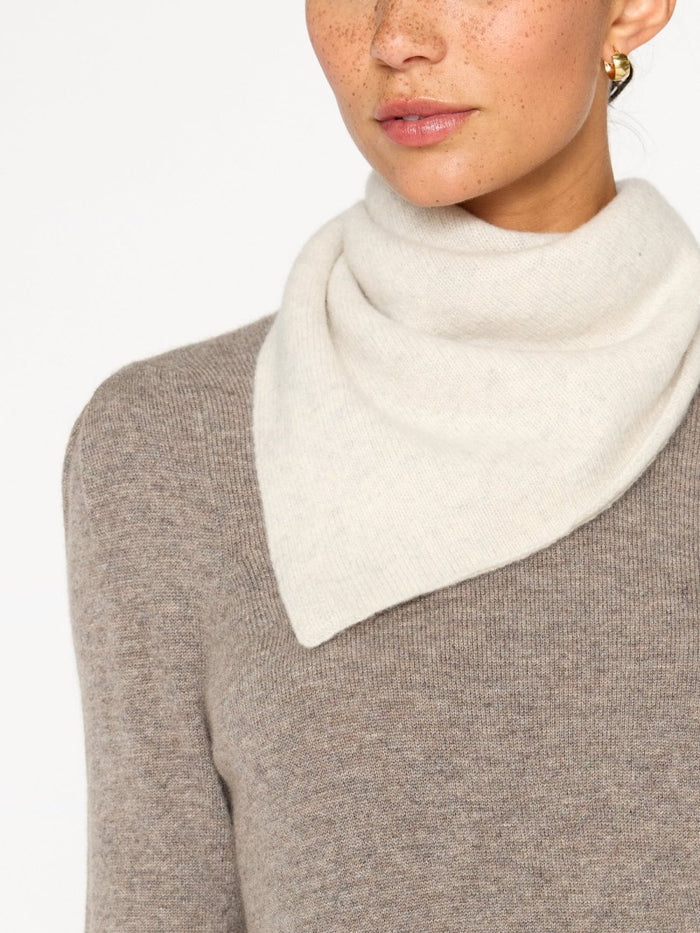 Ivory cashmere neck square knotted over a taupe cashmere sweater.