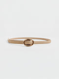 Tan suede belt with an oval gold buckle, looped on a plain background