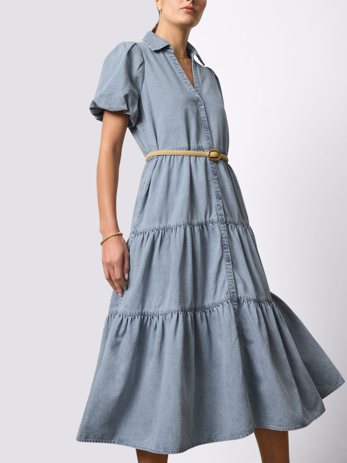 Woman wearing a light-wash denim Havana tiered midi dress with a tan belt