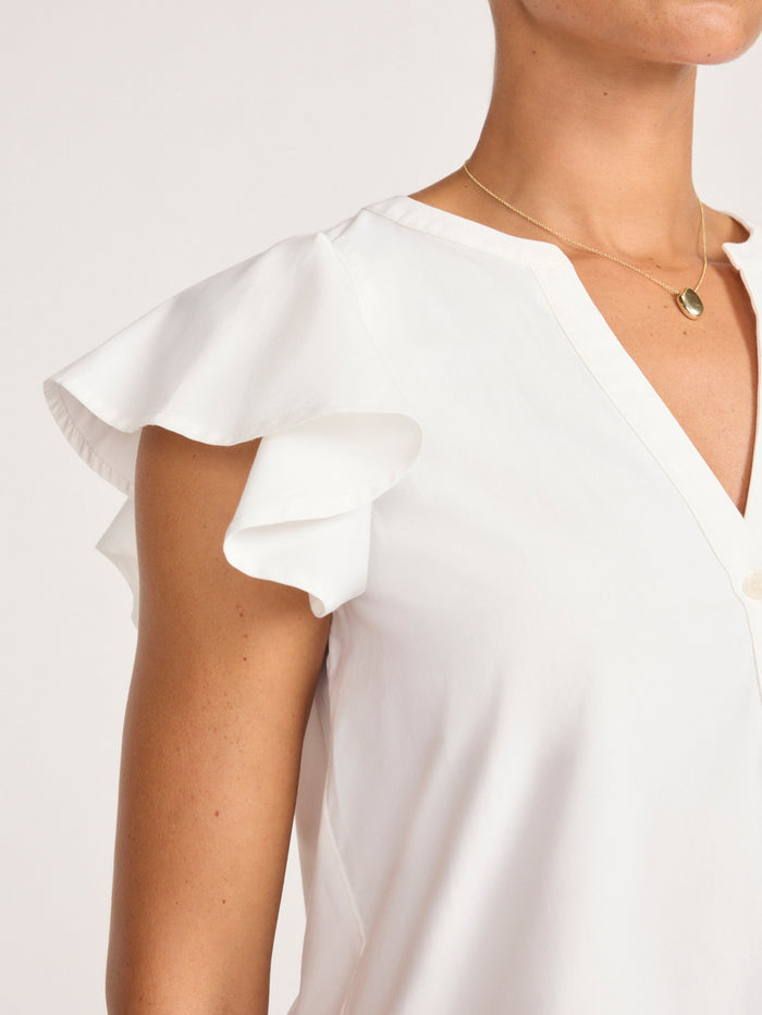 Close-up of the flutter sleeve and V-neckline on a white blouse