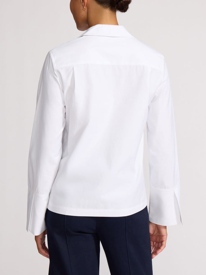 Back view of a white cotton popover shirt with pleated cuffed sleeves