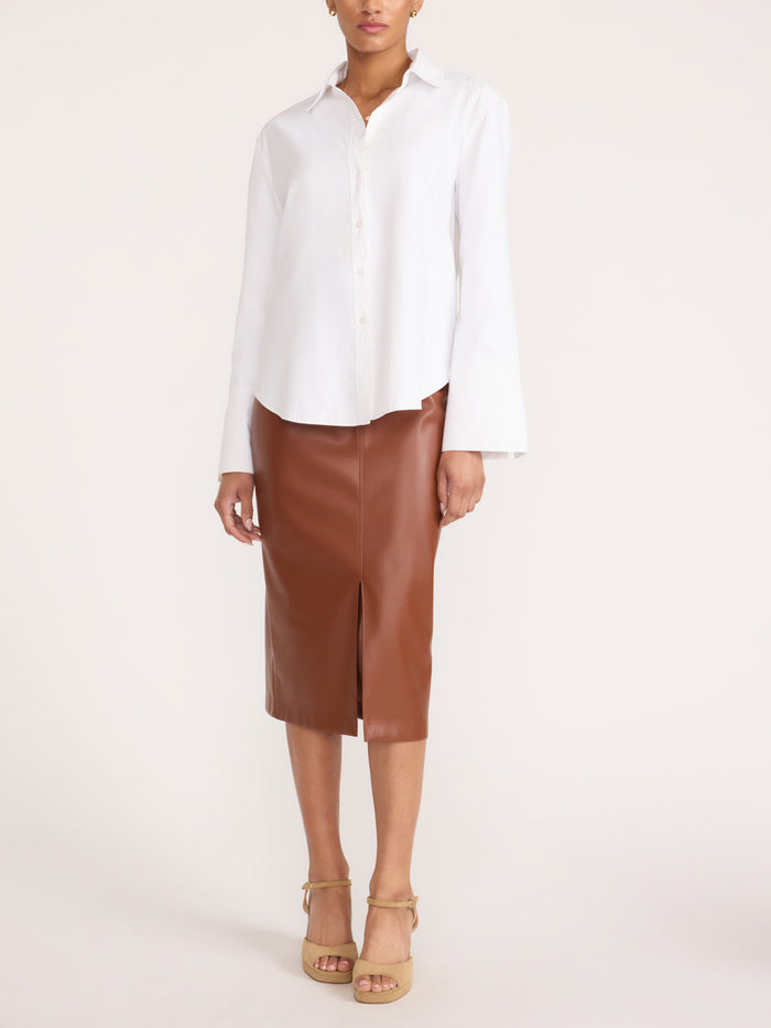 Button-up shirt in salt white, styled with a brown faux-leather midi skirt and beige platform sandals