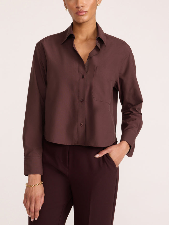 Women's dark brown cropped button-up shirt with a chest pocket, styled with matching trousers