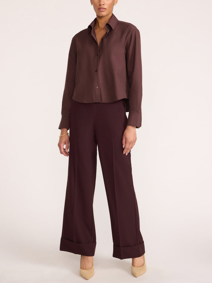 Women's dark brown cropped button-up shirt styled with wide-leg trousers and pointed-toe heels