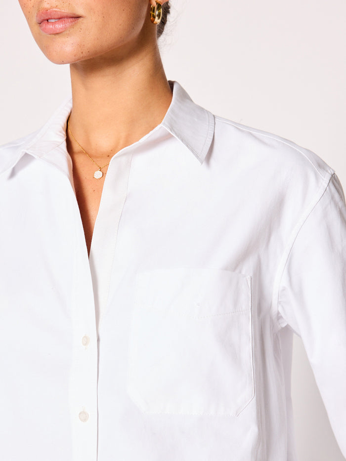 Close-up of a white button-down shirt collar and chest pocket detail