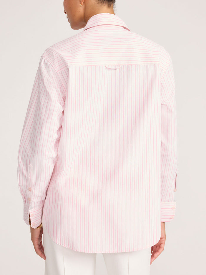 Back view of a pink and white striped button-down shirt paired with white trousers