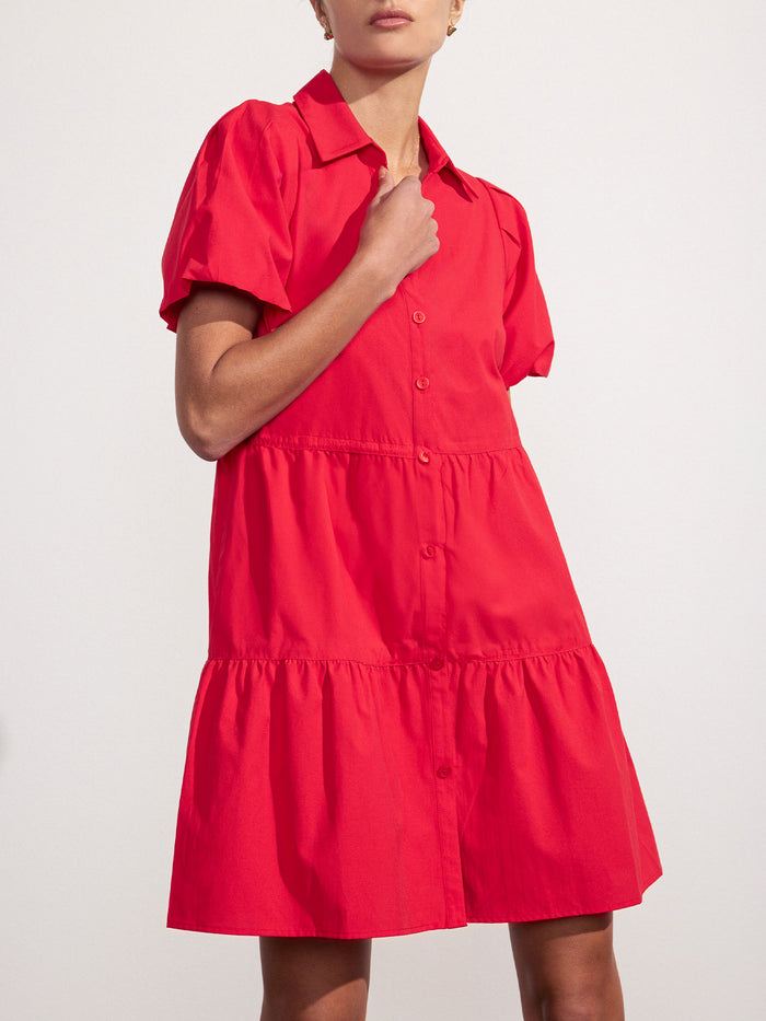 Woman wearing a red tiered mini shirtdress with puff sleeves and a collared button-front