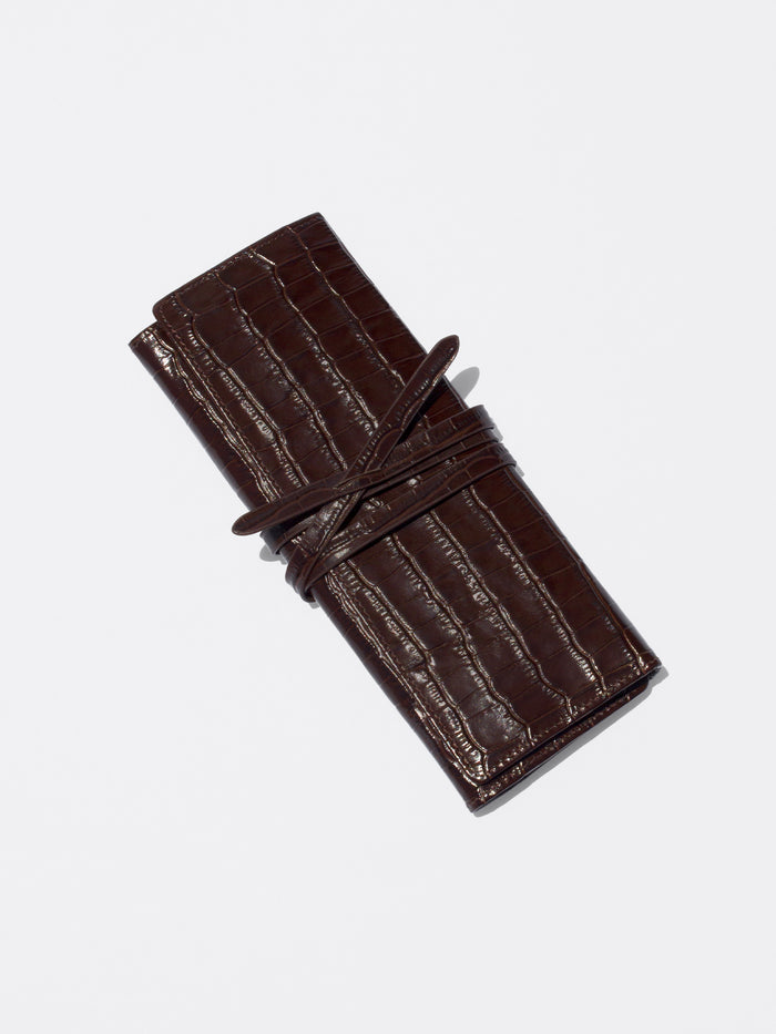 Dark brown crocodile-embossed leather document holder wrapped with a matching leather tie strap