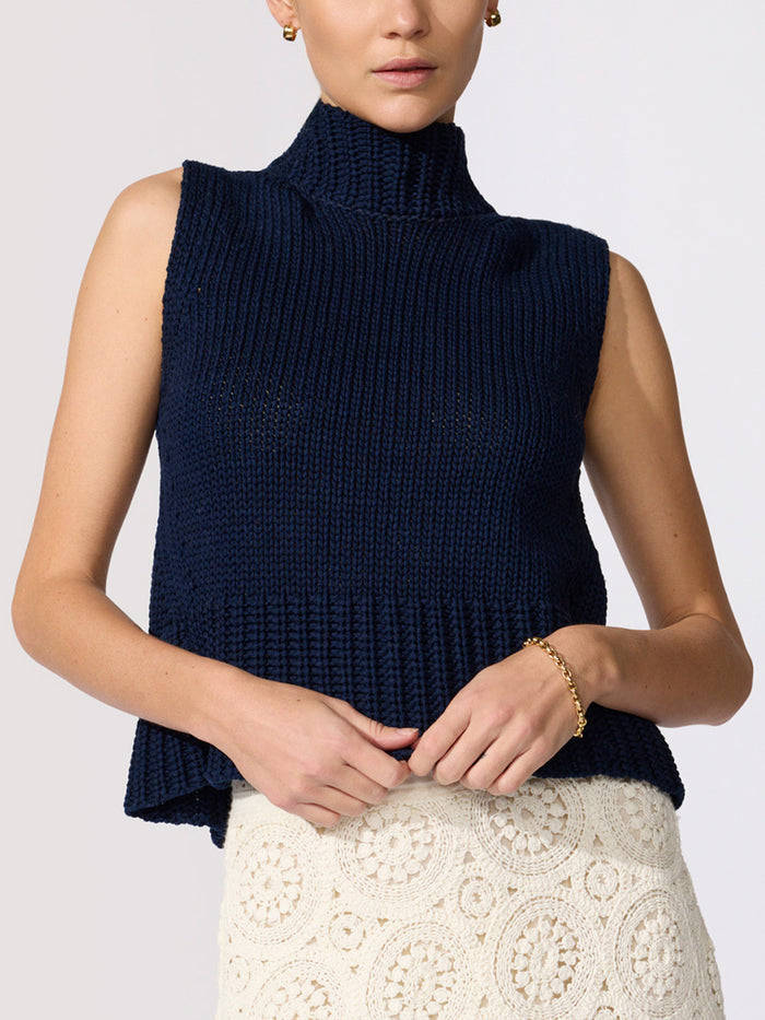navy chunky knit sleeveless turtleneck vest styled with ivory crochet skirt and gold jewelry