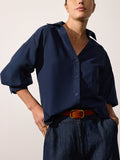 Kate shirt in navy with voluminous puff sleeves, tucked into indigo jeans with a tan leather belt