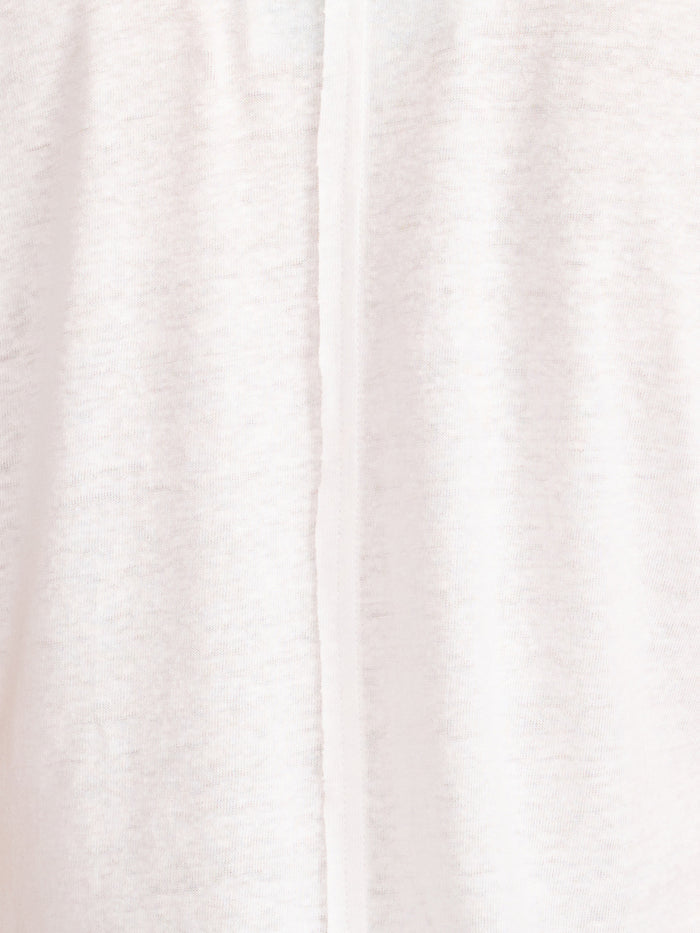 Close-up fabric detail of the white Koda tee showing its lightweight slub-knit texture and center seam.