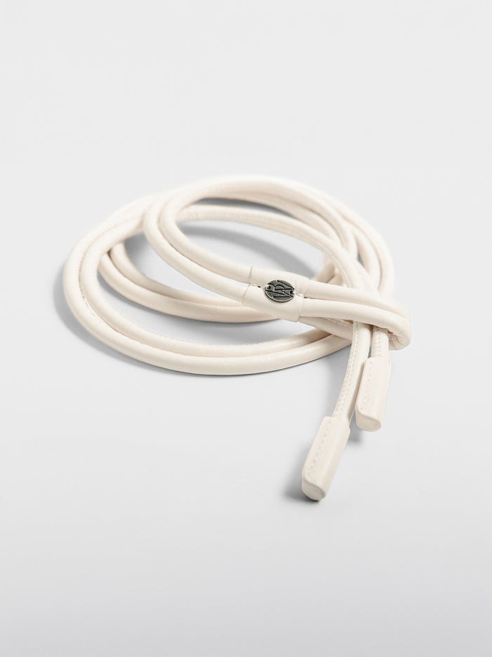 Coiled ivory leather tie belt with logo hardware, overhead product shot