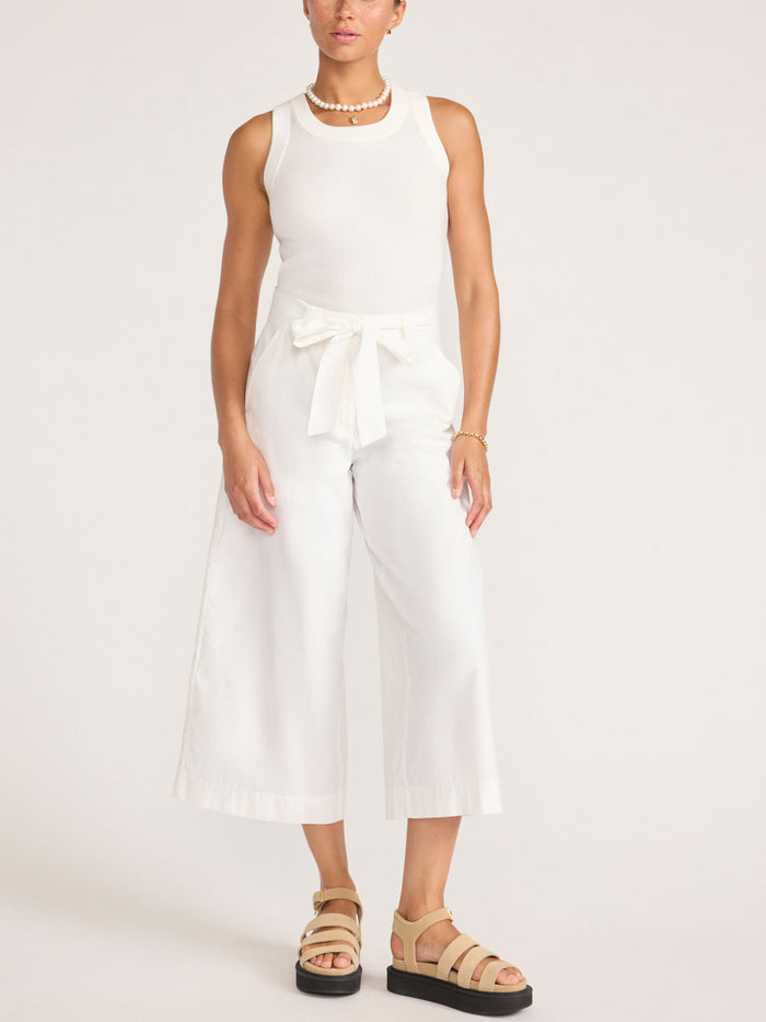 Full-length look featuring the white Leo Tank with ivory wide-leg cropped pants and tan platform sandals.