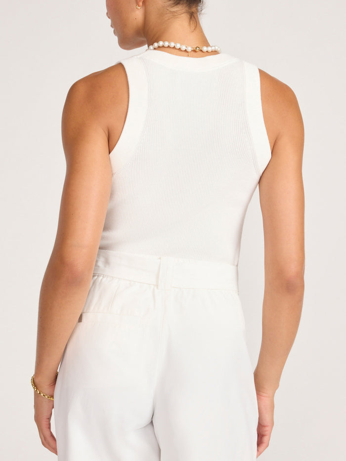 Back view of the white Leo Tank tucked into ivory women's pants, finished with pearl jewelry.