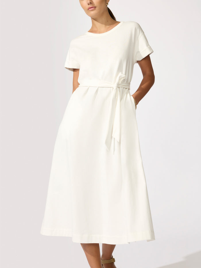 Front view of a woman wearing an ivory midi t-shirt dress with a tie waist