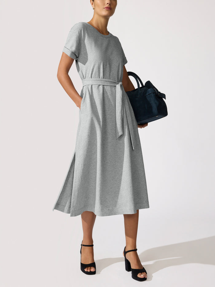 Woman wearing the Marah Dress in Pebble Grey Melange, a grey heathered T-shirt dress with a tie waist