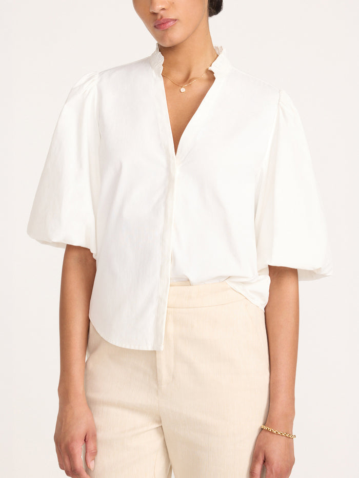 Front view of the Marla Shirt in Salt White with balloon sleeves, styled with beige trousers