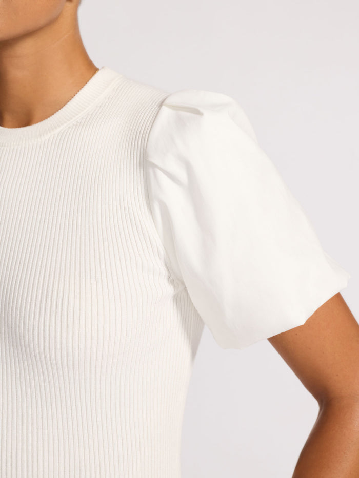 Close-up of an ivory ribbed knit top with a puffed short sleeve