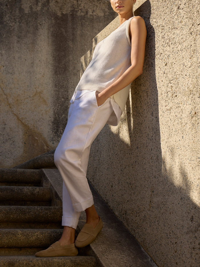 Morrow sleeveless knit top and cropped trousers in white, full-length view against a stone wall