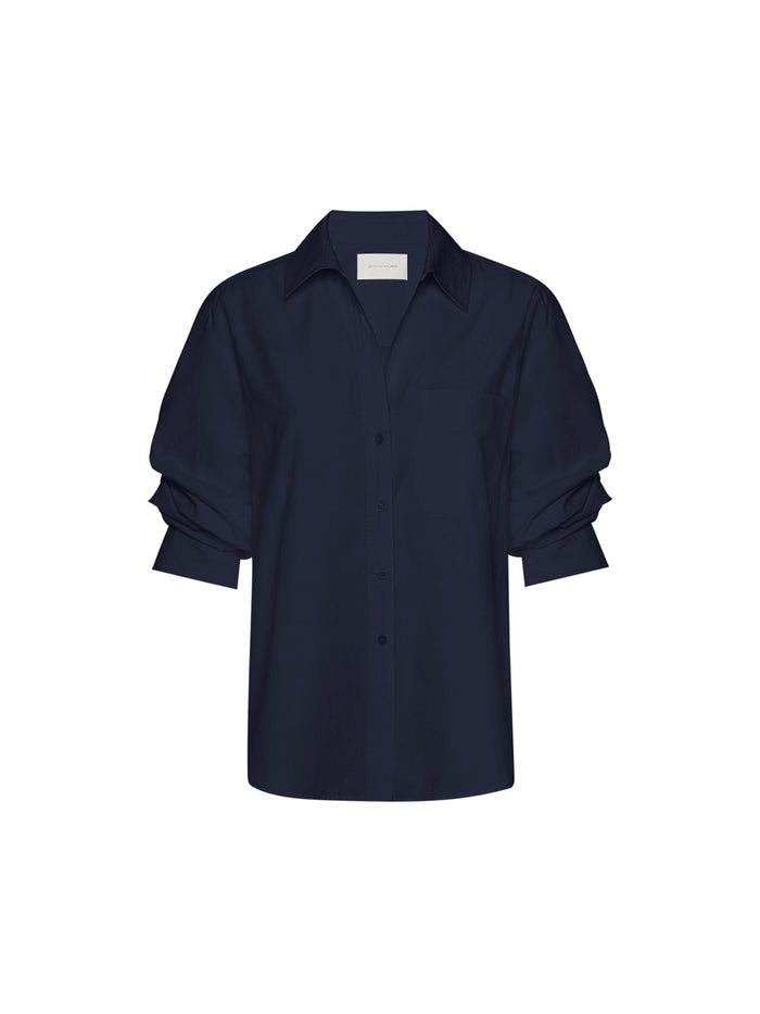 Button-down shirt in navy, flat lay product shot with rolled three-quarter sleeves