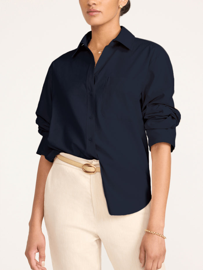 Button-down shirt in navy, styled with rolled sleeves and cream trousers