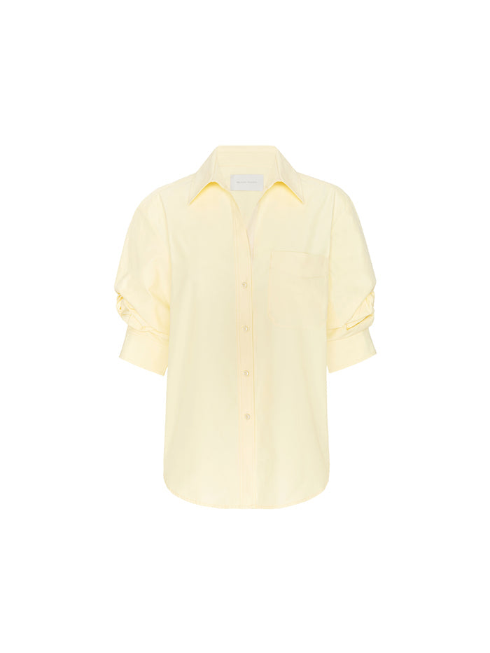 Pale yellow long-sleeve button-down shirt with a chest pocket on a plain background