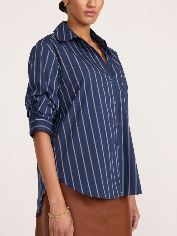 Pia shirt in Hartford stripe, model wearing navy pinstripe button-up shirt with brown leather-look skirt