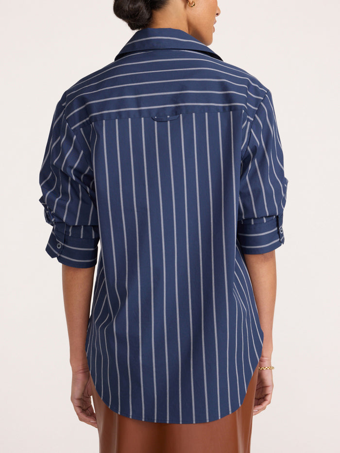 Pia shirt in Hartford stripe, back view of model wearing navy pinstripe button-up shirt with rolled sleeves and brown pants