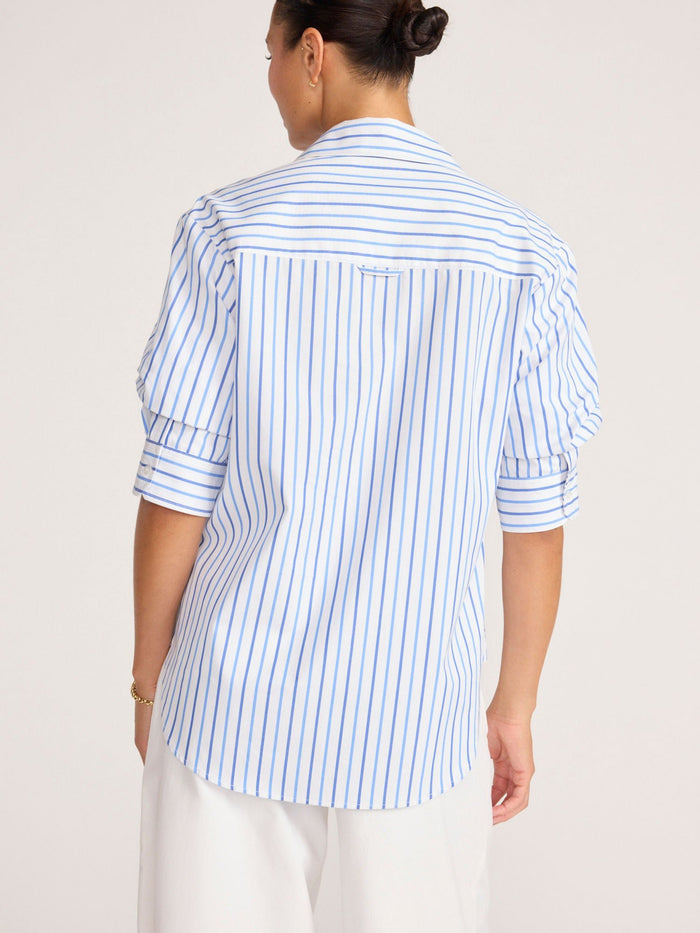 Back view of a model wearing a blue and white striped button-up shirt