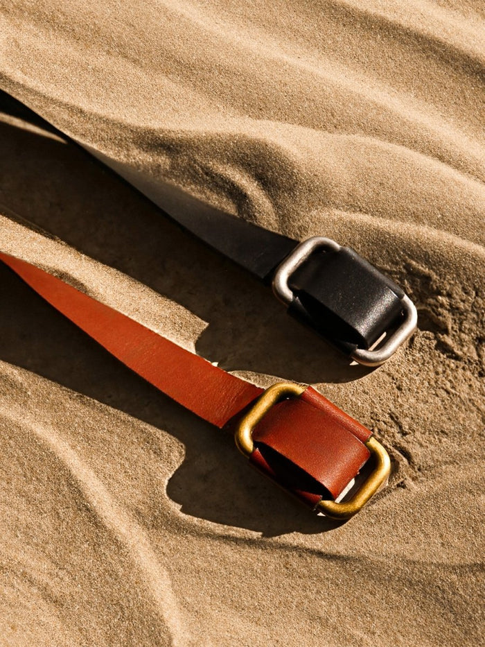 Saddle brown & black leather buckle belts close up