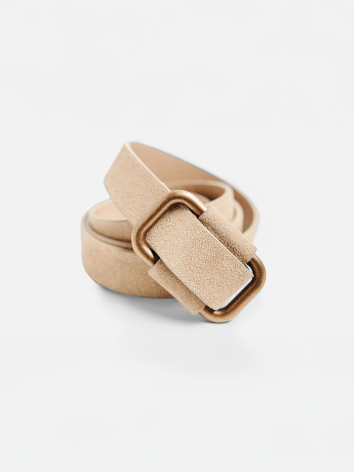 Tan suede belt with a large square gold buckle, coiled on a plain background